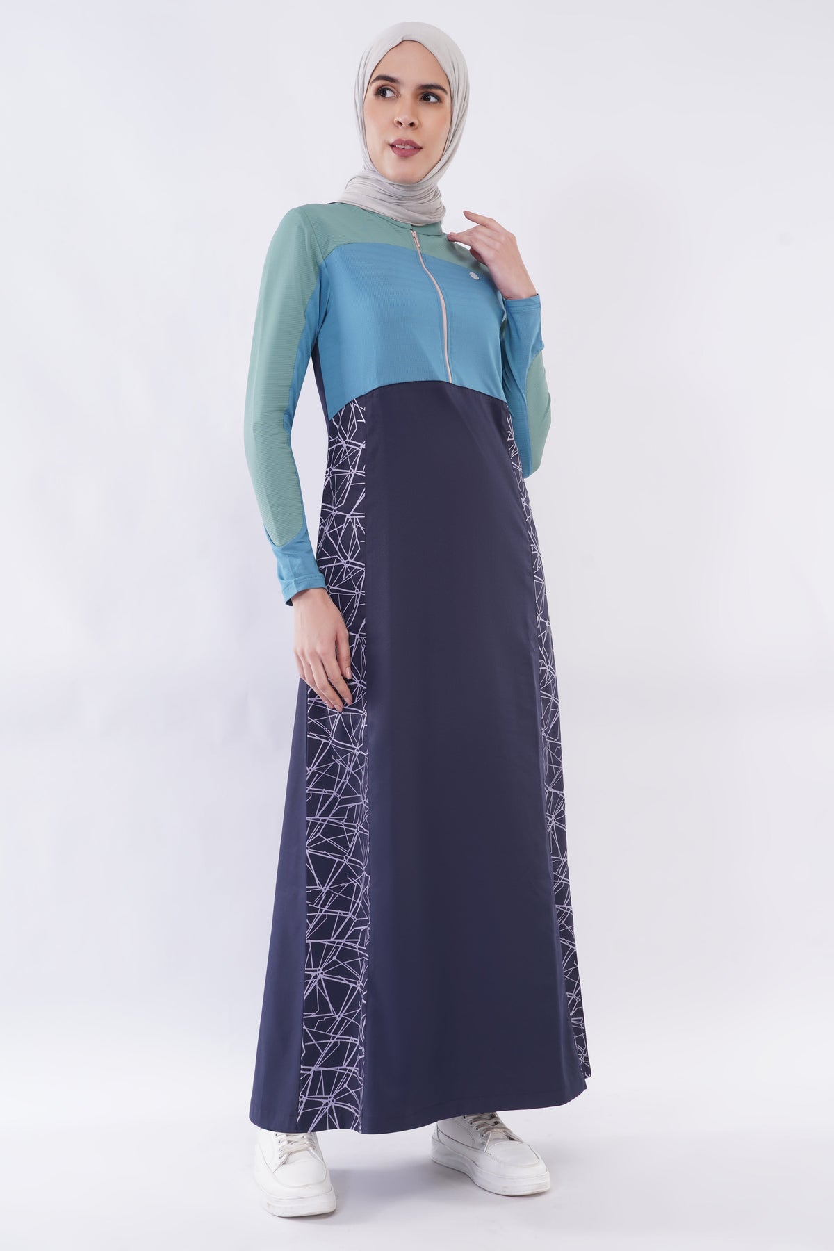 alwaan Oceanic Breeze jilbab in navy blue and sage green with geometric side panels, zip front, and band collar.