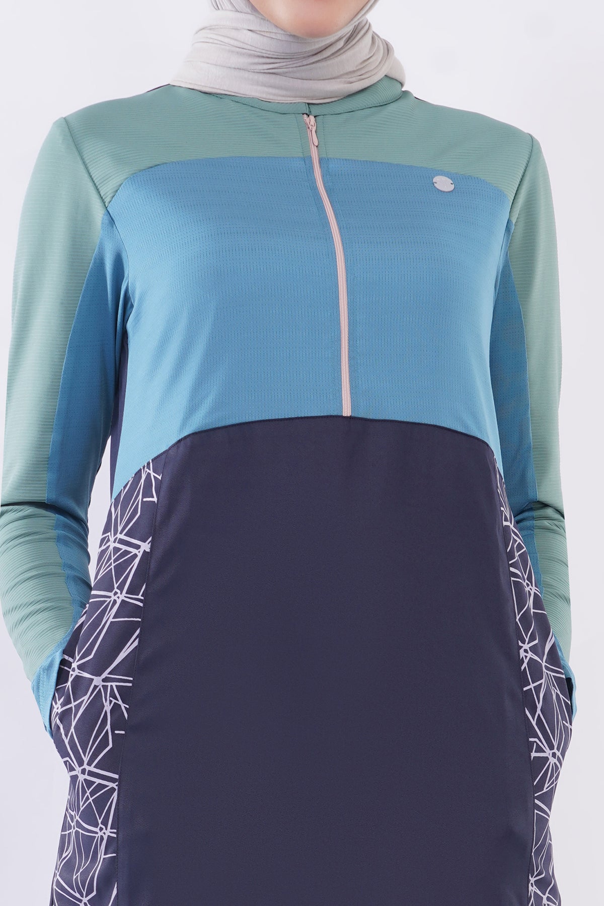 alwaan Oceanic Breeze jilbab in navy blue and sage green with geometric side panels, zip front, and band collar